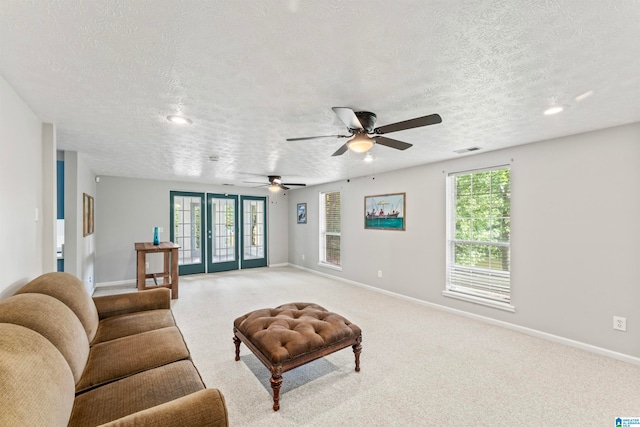 living room with ceiling fan, french doors, and a textured ceiling