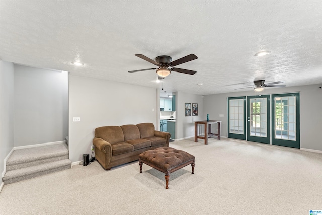 living room with ceiling fan, light colored carpet, and a textured ceiling