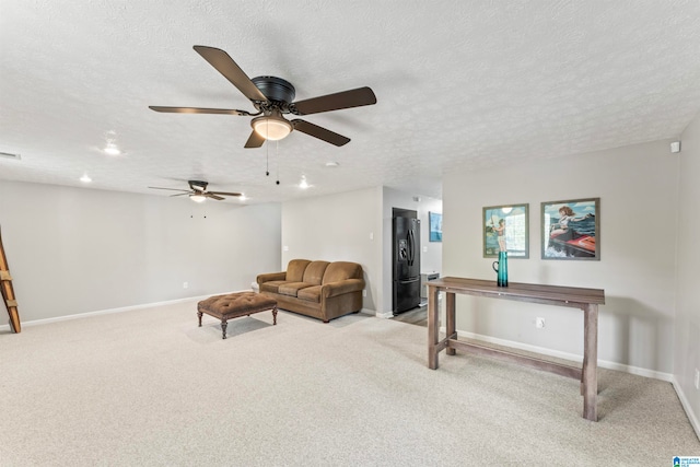 living room with ceiling fan, light colored carpet, and a textured ceiling