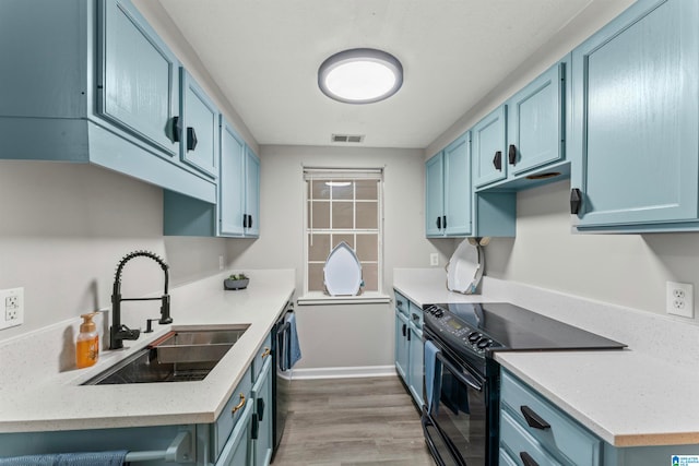 kitchen with blue cabinetry, black appliances, light hardwood / wood-style flooring, and sink