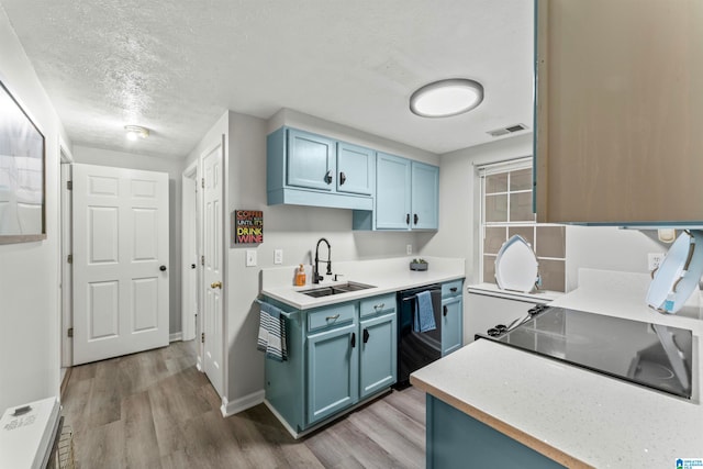 kitchen with blue cabinetry, a textured ceiling, light wood-type flooring, and black appliances