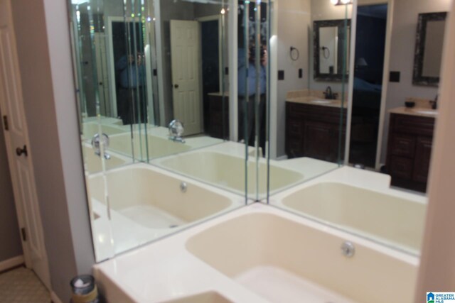 bathroom with vanity and a bath