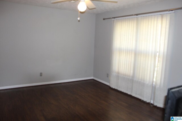 spare room with ceiling fan, dark wood-type flooring, and a textured ceiling