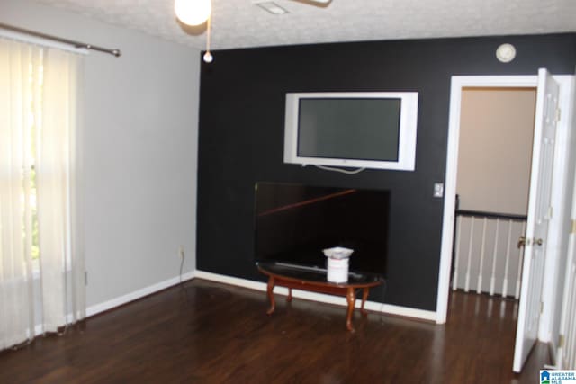 interior space with ceiling fan, dark hardwood / wood-style floors, and a textured ceiling