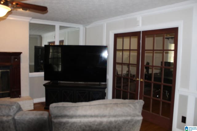 living room featuring ceiling fan, a textured ceiling, hardwood / wood-style floors, and ornamental molding