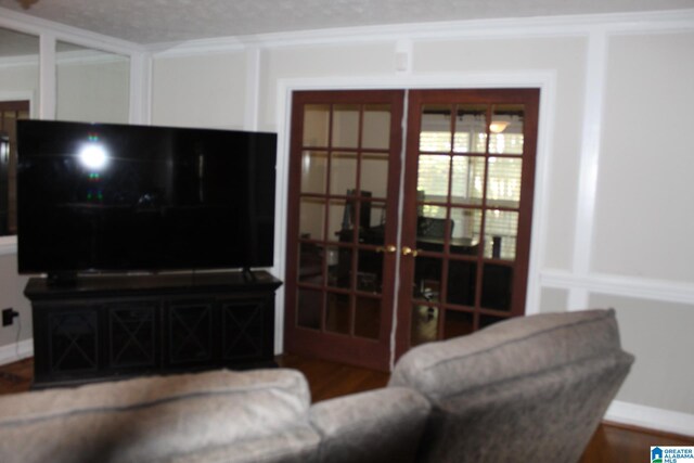 living room featuring hardwood / wood-style flooring, crown molding, french doors, and a textured ceiling