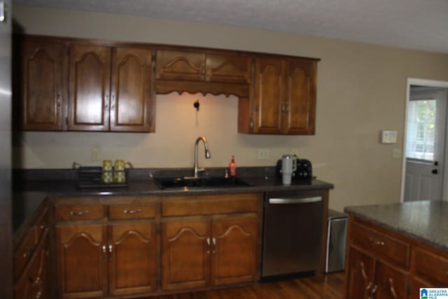 kitchen with dark hardwood / wood-style floors, sink, and stainless steel dishwasher