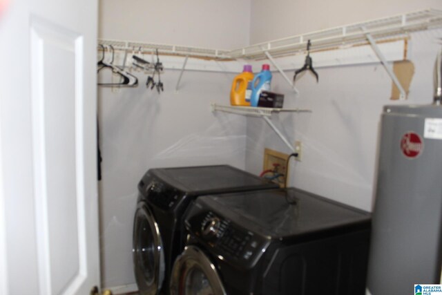 washroom with washing machine and dryer and water heater