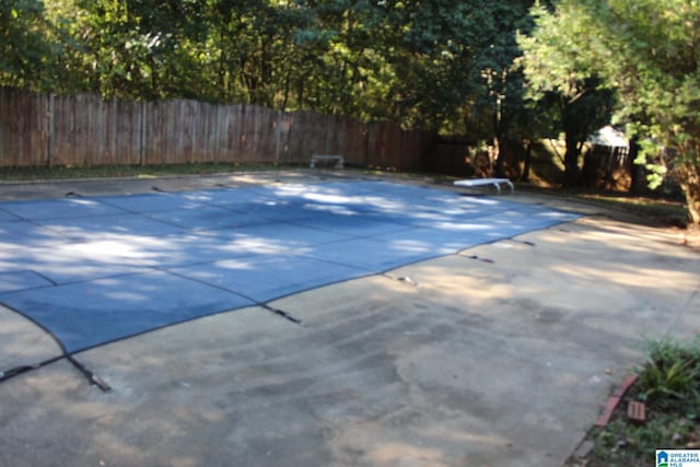 view of pool with a diving board and a patio