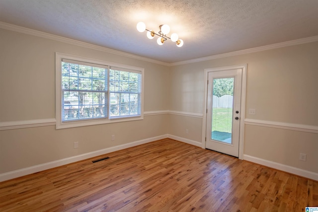 interior space with wood-type flooring, crown molding, a chandelier, and a textured ceiling