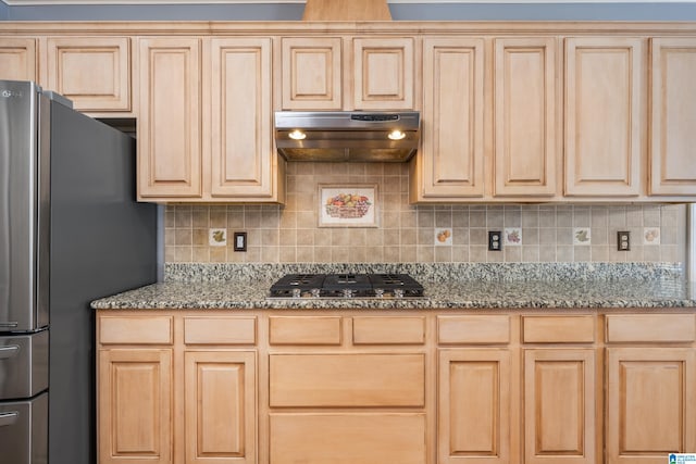 kitchen with appliances with stainless steel finishes, light brown cabinets, and stone counters