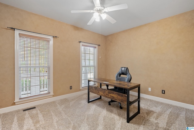 office featuring light colored carpet, a healthy amount of sunlight, and ceiling fan