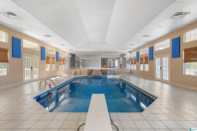 view of pool with french doors and a diving board