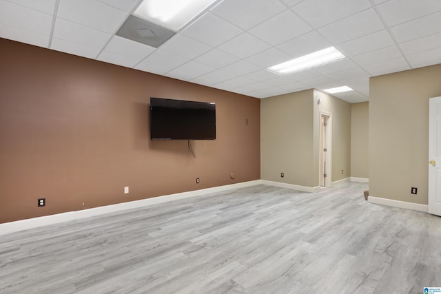 basement featuring a drop ceiling and light hardwood / wood-style flooring