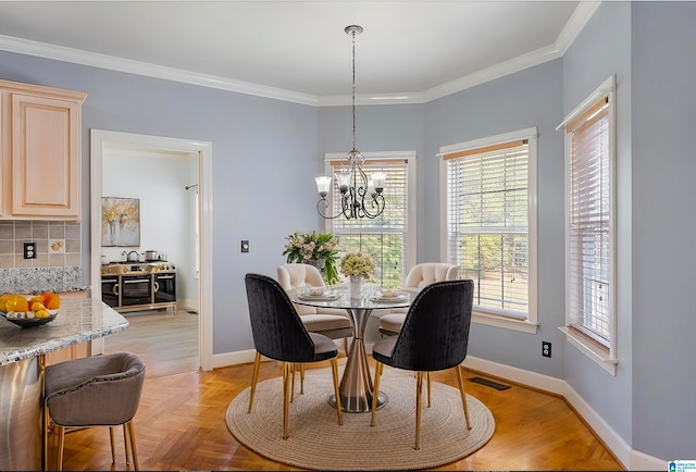 dining room featuring crown molding, light parquet floors, and a notable chandelier