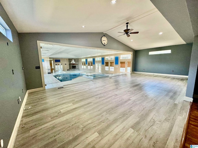 unfurnished living room with vaulted ceiling, light hardwood / wood-style floors, and ceiling fan