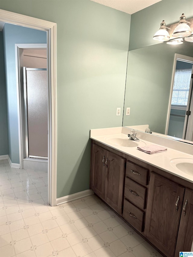 bathroom featuring vanity, a textured ceiling, and a shower with door