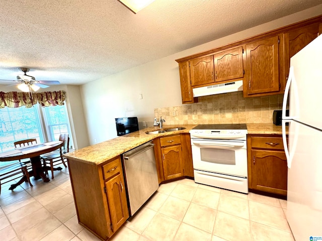 kitchen featuring ceiling fan, sink, kitchen peninsula, white appliances, and decorative backsplash