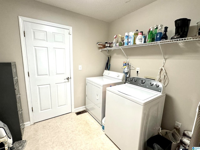 laundry room featuring washer and dryer and a textured ceiling