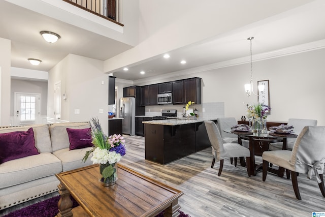 living room featuring light hardwood / wood-style floors, crown molding, and sink