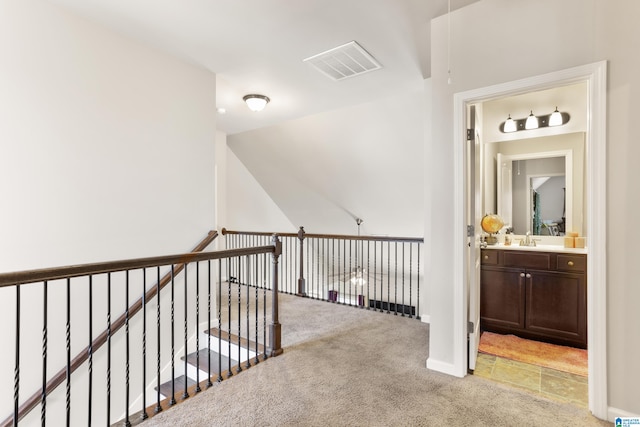 hallway with sink and light carpet