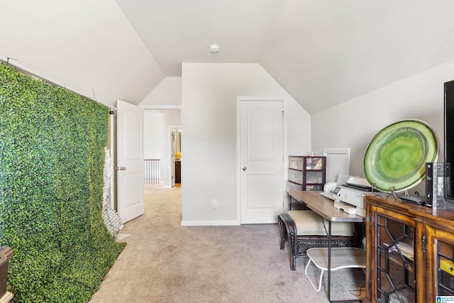 carpeted office space featuring vaulted ceiling