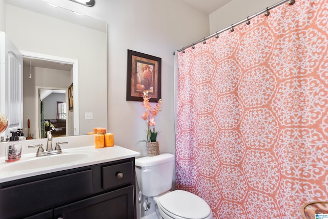 bathroom featuring vanity, a shower with shower curtain, and toilet