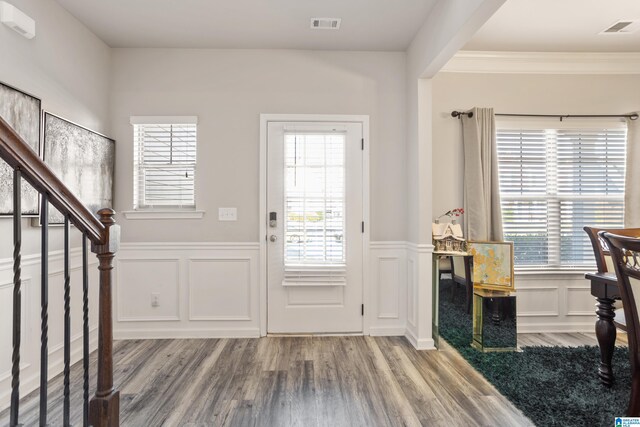 foyer entrance with crown molding, a healthy amount of sunlight, and hardwood / wood-style floors