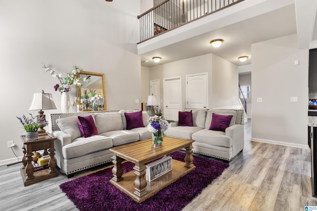 living room featuring light hardwood / wood-style flooring and a high ceiling