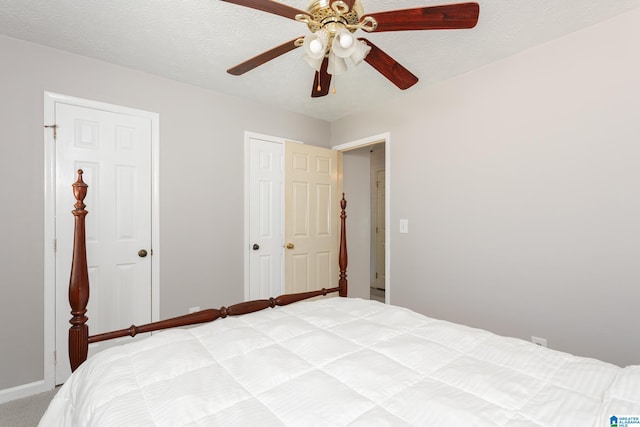 unfurnished bedroom featuring ceiling fan, carpet floors, and a textured ceiling