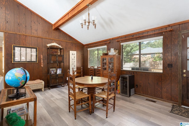 dining space featuring wood walls, light hardwood / wood-style floors, and lofted ceiling with beams