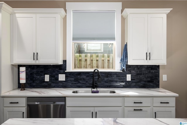 kitchen featuring dishwasher, white cabinets, sink, and decorative backsplash