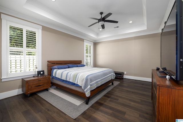 bedroom featuring ceiling fan, a raised ceiling, and dark hardwood / wood-style floors