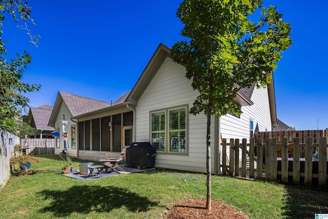 rear view of house with a yard and a sunroom