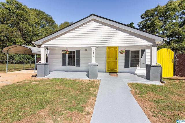 bungalow-style house featuring a porch, a carport, and a front yard