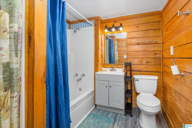 full bathroom with vanity, toilet, wooden walls, shower / bath combo with shower curtain, and hardwood / wood-style floors