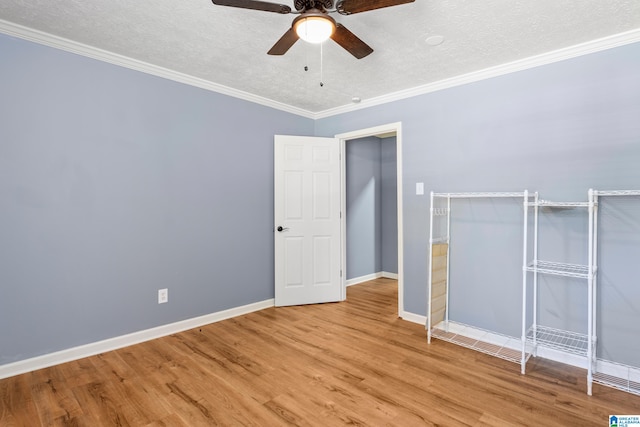 spare room with light hardwood / wood-style floors, ornamental molding, and a textured ceiling