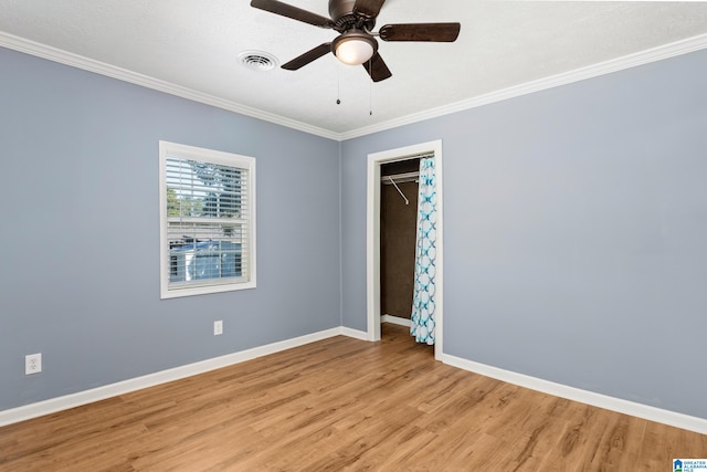 empty room with light hardwood / wood-style floors, ornamental molding, and ceiling fan