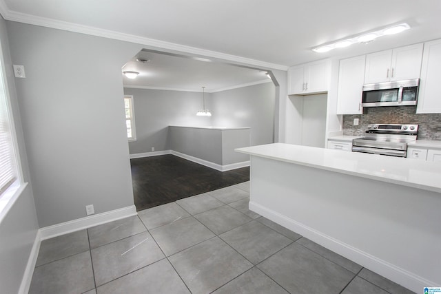 kitchen featuring tile patterned flooring, tasteful backsplash, decorative light fixtures, white cabinetry, and stainless steel appliances