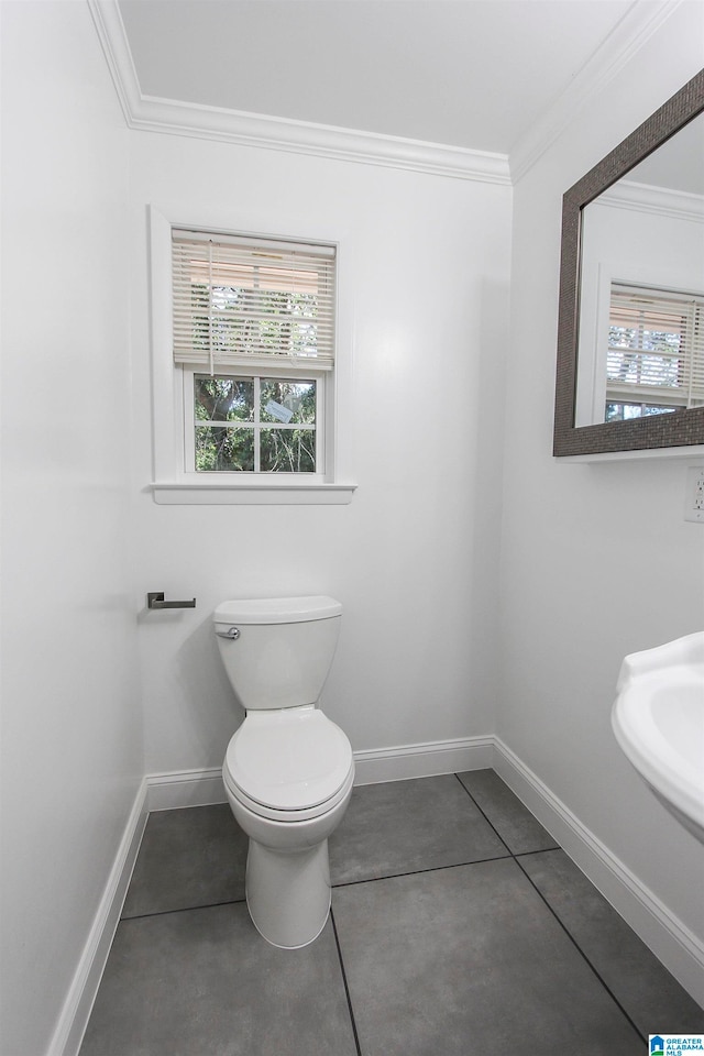 bathroom with tile patterned floors, toilet, and crown molding