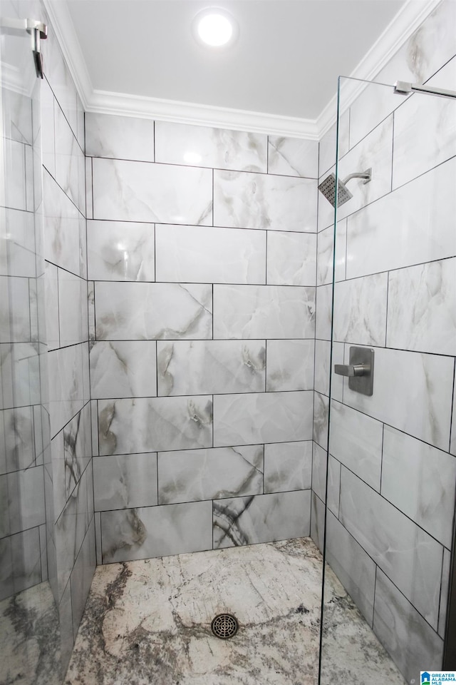 bathroom featuring a tile shower and crown molding