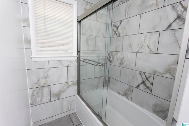 bathroom with shower / bath combination with glass door and tile patterned floors