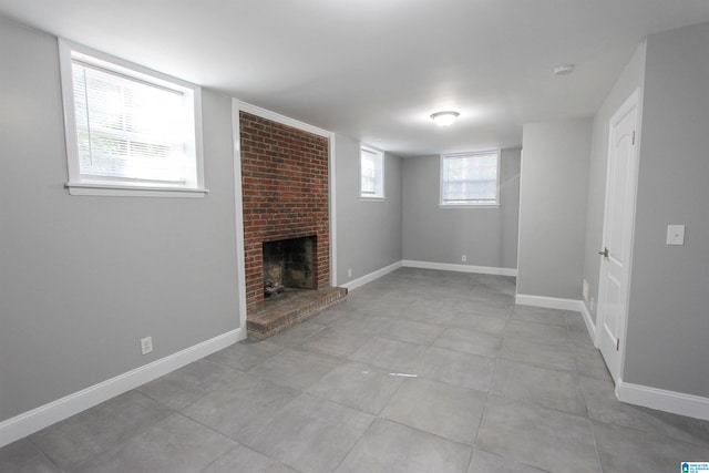 basement with a brick fireplace and a wealth of natural light