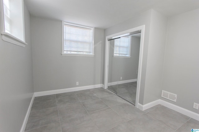 unfurnished bedroom featuring tile patterned floors and a closet