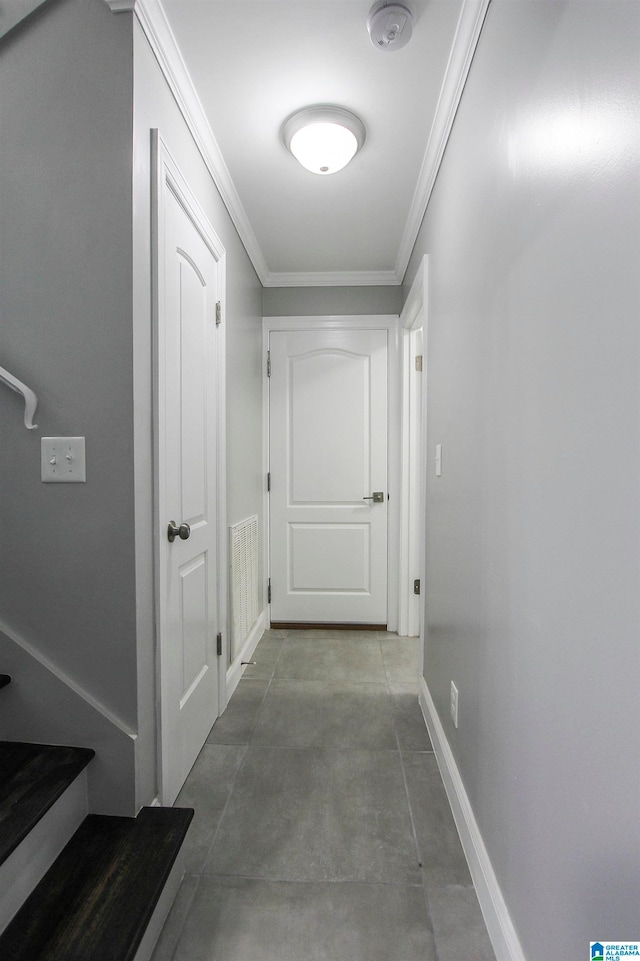 hall with concrete floors and crown molding