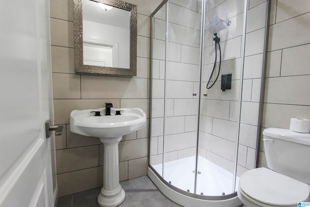 bathroom with an enclosed shower, tile walls, and toilet