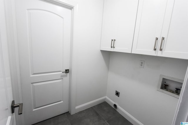 clothes washing area featuring electric dryer hookup, hookup for a washing machine, dark tile patterned floors, and cabinets