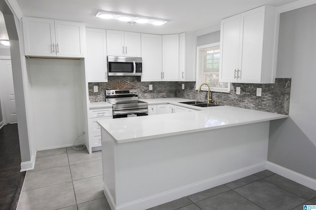 kitchen with white cabinetry, sink, tasteful backsplash, light tile patterned floors, and appliances with stainless steel finishes