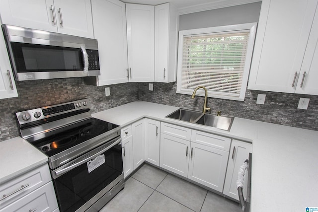 kitchen featuring sink, white cabinetry, stainless steel appliances, and light tile patterned floors