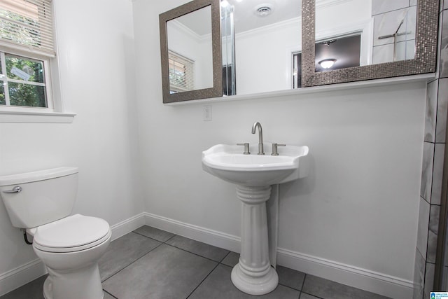 bathroom with tile patterned flooring, toilet, and crown molding